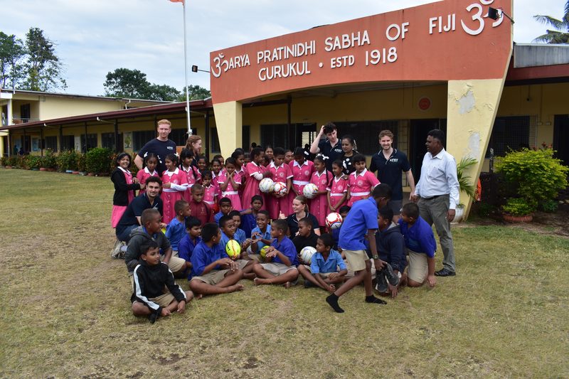 Students and KFK volunteers with donated balls outside a Fijian school