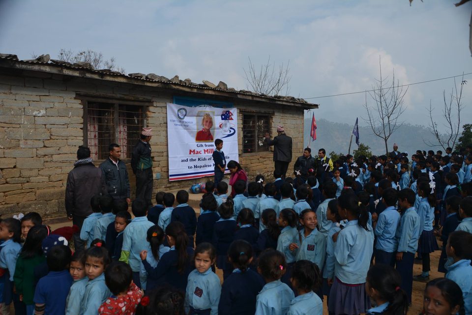 Hundreds of Nepalese school children gathered at a mountain village school beneath a banner reading 'Gift from Mac Millar and the Kids of Australia to Nepalese Kids'