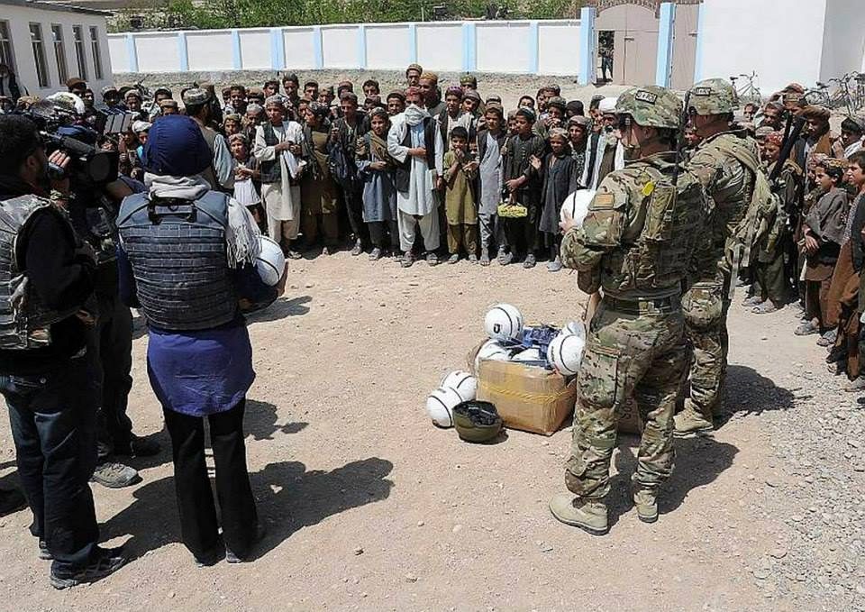 Australian soldiers distributing soccer balls to a crowd of children in Tarin Kot, Afghanistan